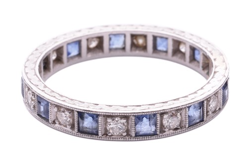 Lot 128 - A sapphire and diamond eternity ring,...