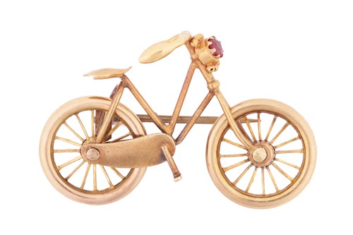 Lot 88 - A bicycle brooch with a pink paste accent,...