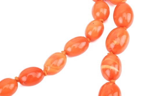 Lot 24 - A butterscotch oval amber bead necklace,...