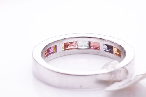 Lot 184 - A gem-set half hoop eternity ring. Set with...