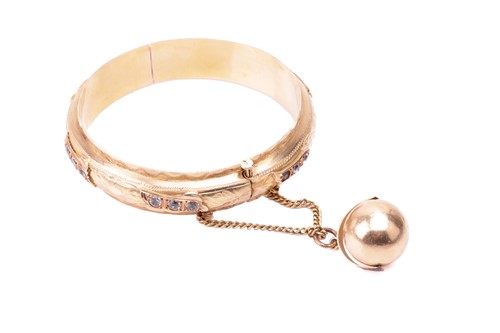 Lot 187 - A yellow metal bangle and attached spherical...