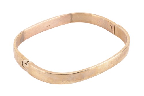 Lot 95 - A hinged bangle in 9ct yellow gold, of angular...