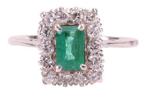 Lot 83 - An emerald and diamond halo ring, centred with...