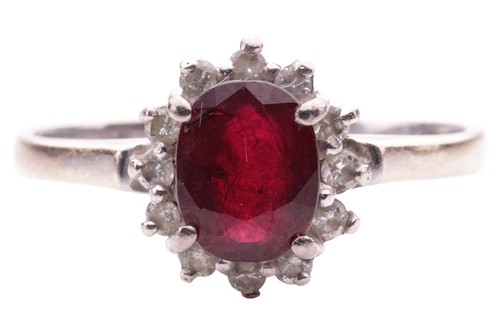 Lot 196 - A ruby and diamond cluster ring, the oval...