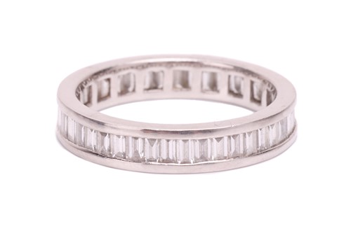 Lot 191 - A baguette cut diamond eternity ring, set with...