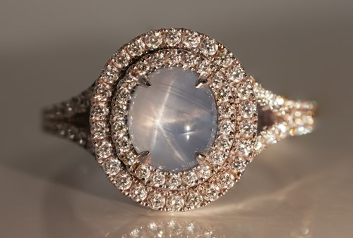 Lot 100 - A star sapphire and diamond cluster ring in...