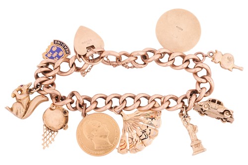 Lot 44 - A 9ct gold charm bracelet featuring nine...
