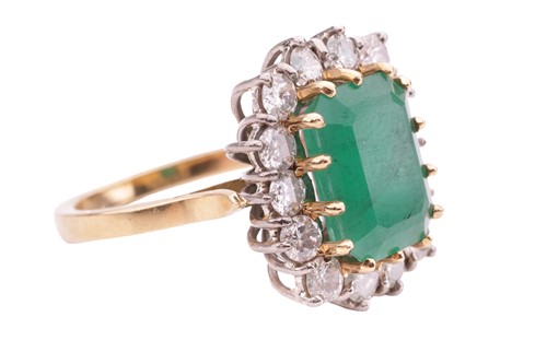 Lot 122 - An emerald and diamond cluster ring, set with...