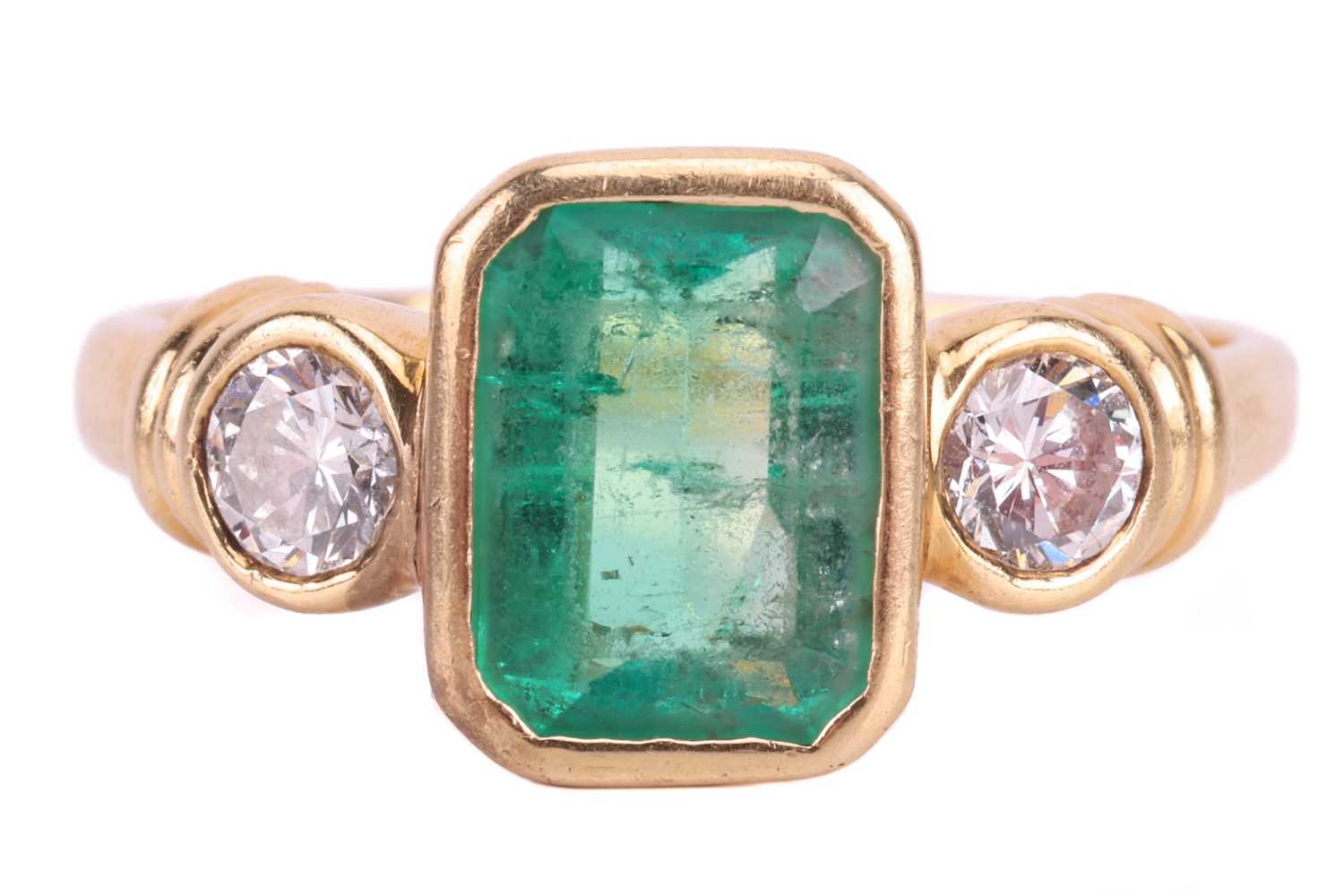 Lot 19 - An emerald and diamond three stone ring, set...