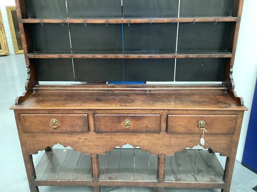 Lot 110 - A George III oak pot board dresser and Delft...
