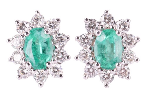 Lot A pair of emerald and diamond halo stud...