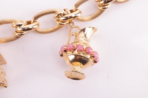 Lot 143 - A charm bracelet comprising a series of hollow...