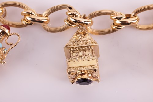 Lot 143 - A charm bracelet comprising a series of hollow...