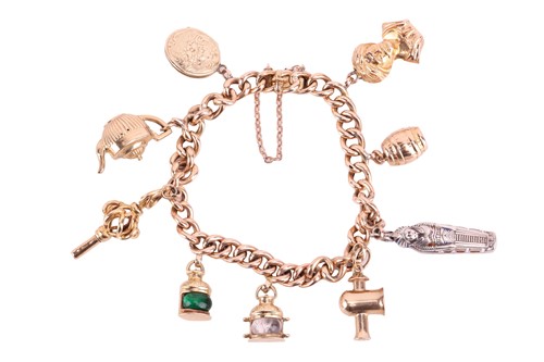 Lot 4 - A charm bracelet featuring nine charms...