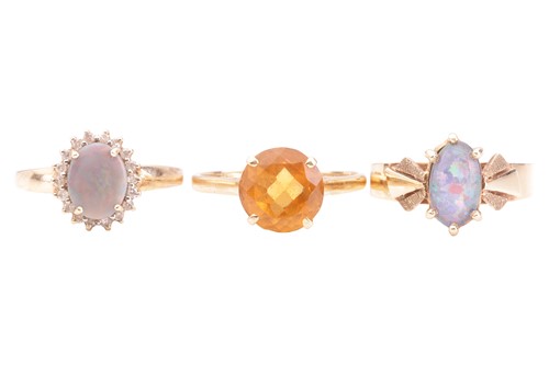 Lot 56 - A collection of three rings; including an opal...