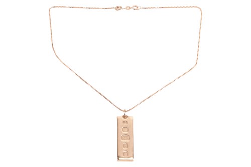 Lot 119 - An Ingot Pendant, hallmarked 9ct gold on a 9ct...
