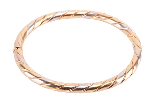 Lot 61 - A hinged bangle in 18ct tri-coloured gold, of...