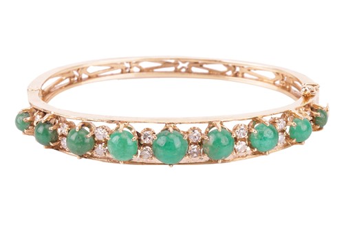 Lot An emerald and diamond bangle, featuring a row...