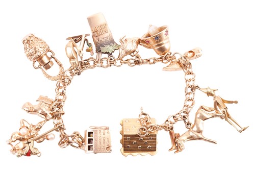 Lot 91 - A charm bracelet with various charms,...