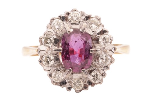 Lot 148 - A ruby and diamond cluster ring. The central...