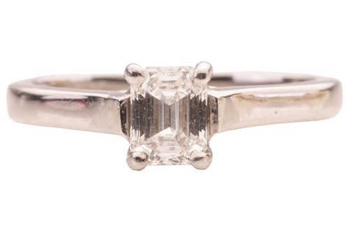 Lot An emerald-cut diamond solitaire ring in...
