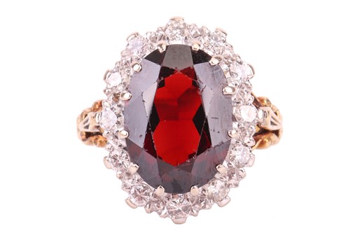 Lot 74 - A garnet and diamond halo ring, centred with...
