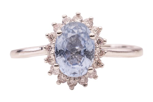 Lot 19 - A sapphire and diamond cluster ring, featuring...