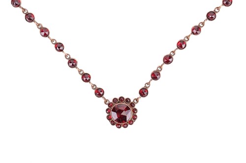 Lot A garnet-set necklace, centred with a circular...