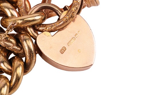Lot 115 - A 15ct gold charm bracelet, the 15ct flat curb-...