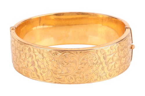 Lot 44 - A hinged bangle in 9ct yellow gold,...