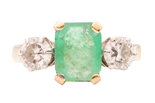 Lot 66 - An emerald and diamond trilogy ring in 18ct...