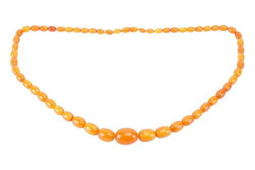 Lot 157 - A single-strand amber bead necklace The row of...