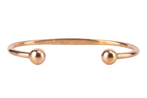 Lot 32 - A torque bracelet in 9ct yellow gold, with...