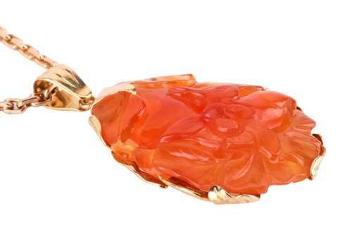 Lot 139 - A carved carnelian pendant on chain, the large...