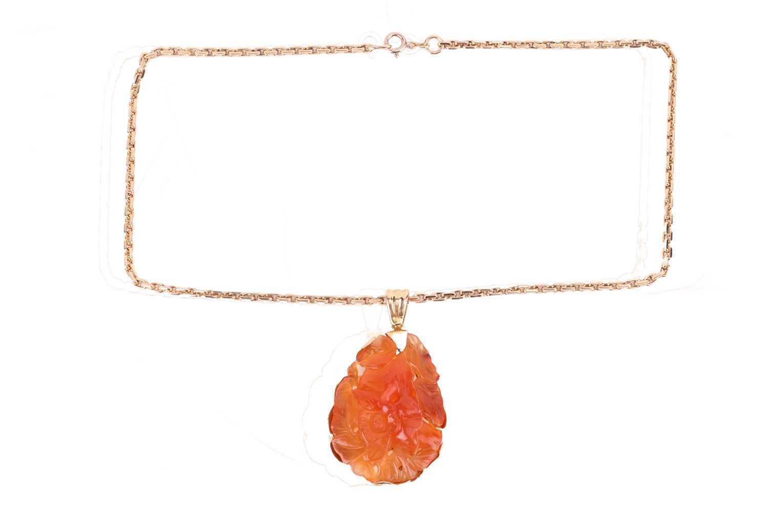 Lot 139 - A carved carnelian pendant on chain, the large...