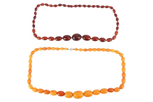 Lot A single-strand amber bead necklace with...