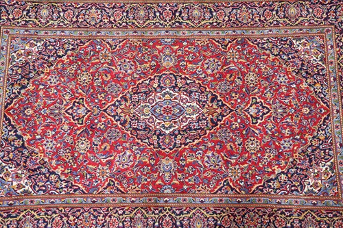 Lot 292 - A red ground Kashan rug with central mandorla...