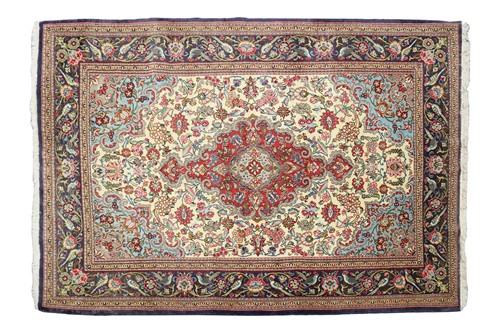 Lot An ivory ground Kerman carpet with a flower...