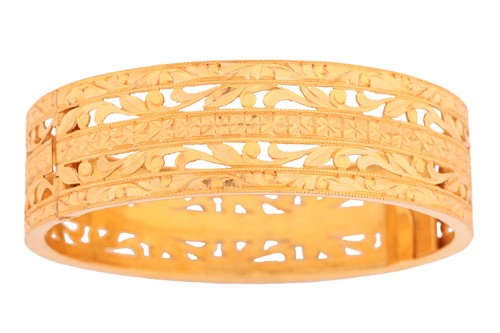 Lot 17 - A hinged bangle of pierced scrollwork design...