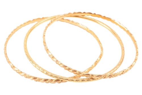 Lot 230 - Three closed bangles; to include a pair with...