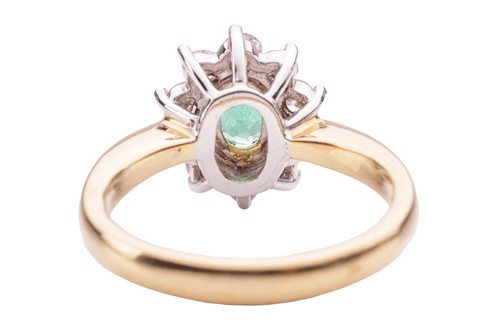 Lot 46 - An emerald and diamond cluster ring in 18ct...