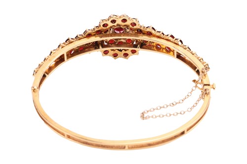 Lot 19 - A garnet-set bangle, of floral design, set...