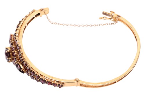 Lot 19 - A garnet-set bangle, of floral design, set...