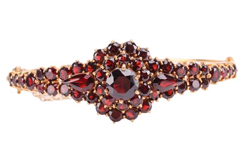 Lot 19 - A garnet-set bangle, of floral design, set...