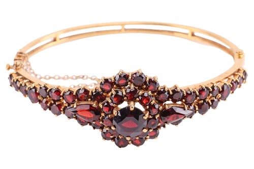 Lot 19 - A garnet-set bangle, of floral design, set...