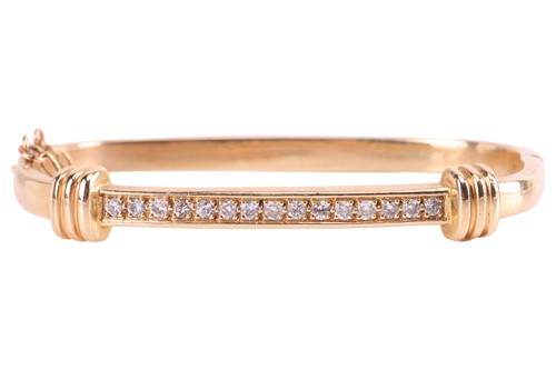 Lot 95 - A diamond-set hinged bangle in 14ct gold,...