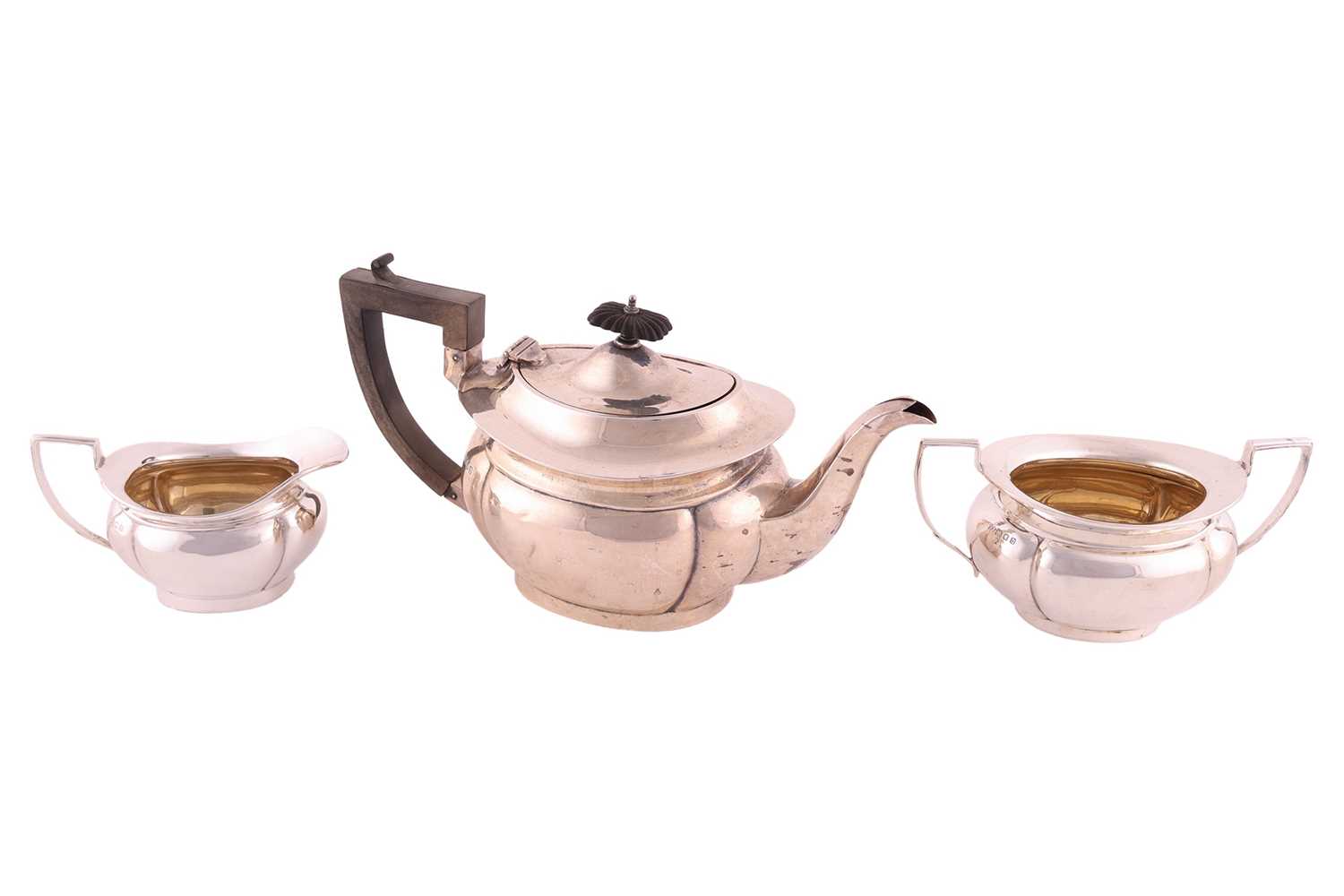 Lot 331 - A three piece silver teaset, of panelled oval...