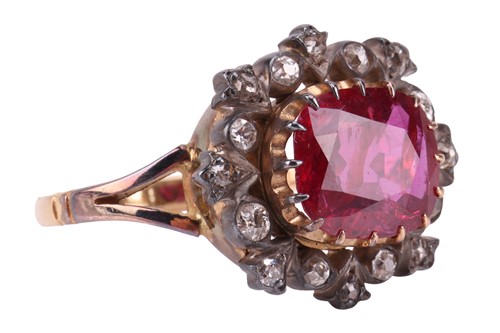 Lot 247 - A ruby and diamond cluster ring, centred with...