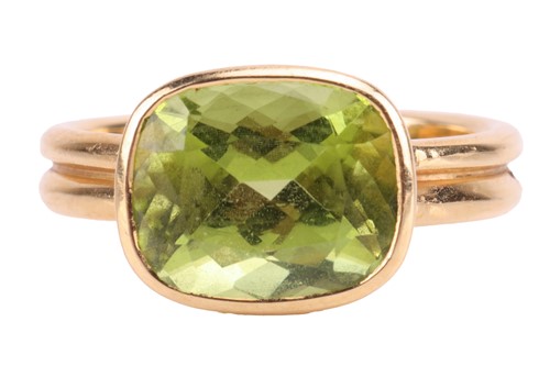 Lot A peridot dress ring in 18ct gold, collet-set...