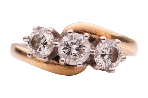 Lot A three-stone diamond crossover ring,...